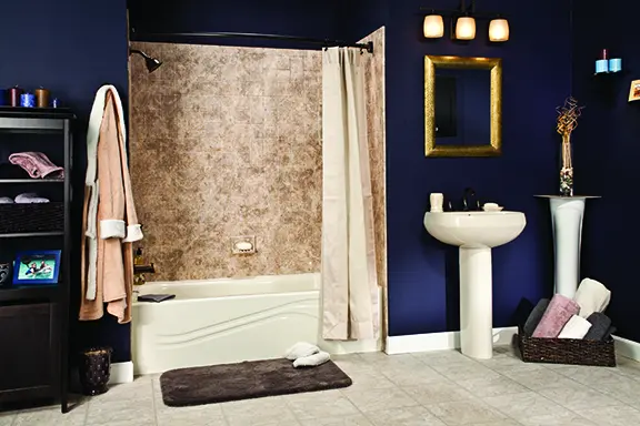 Biscuit tub with brecchia tile walls and oil-rubbed bronze in navy blue bathroom