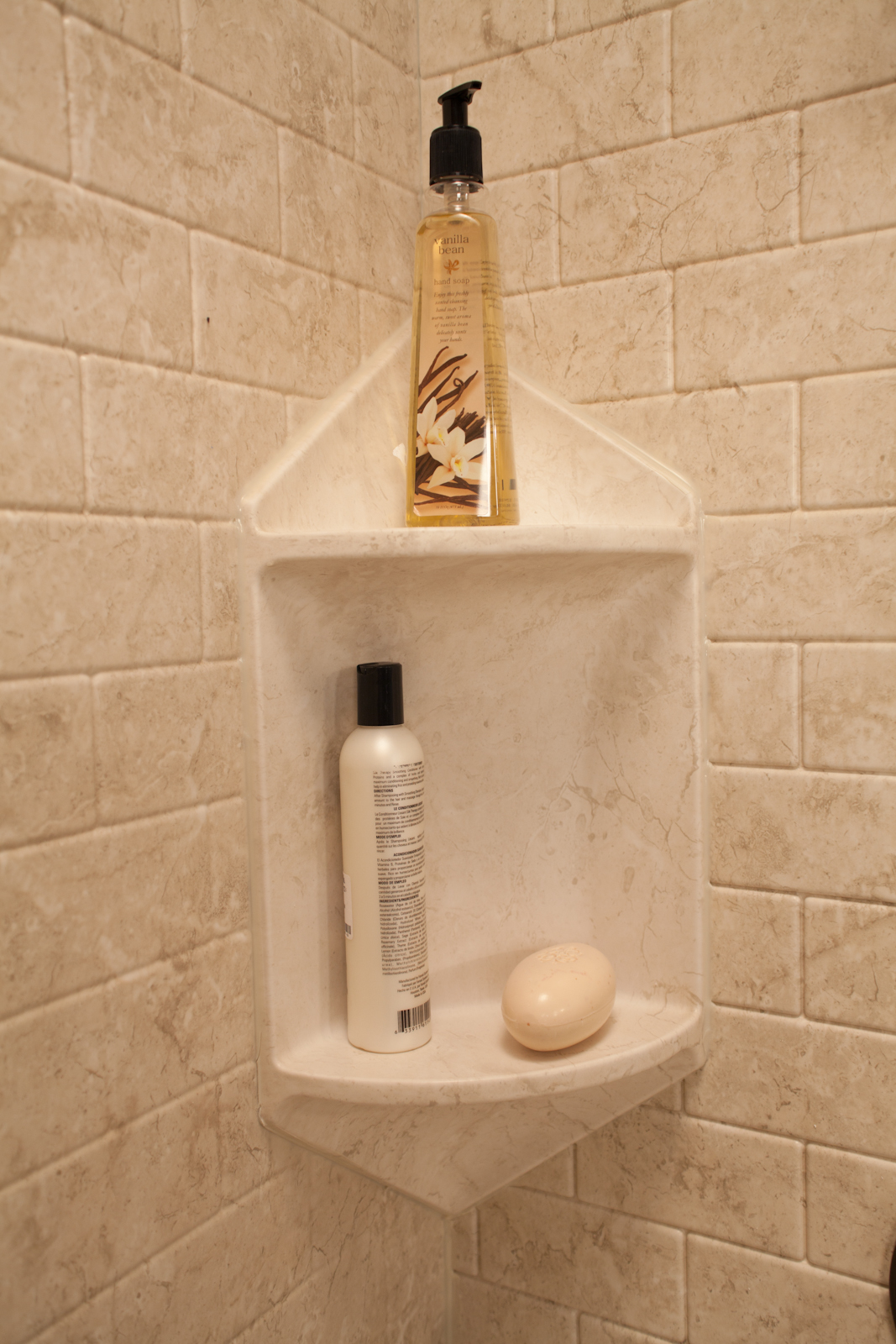 Brecchia two-shelf corner caddy close-up with subway tile walls