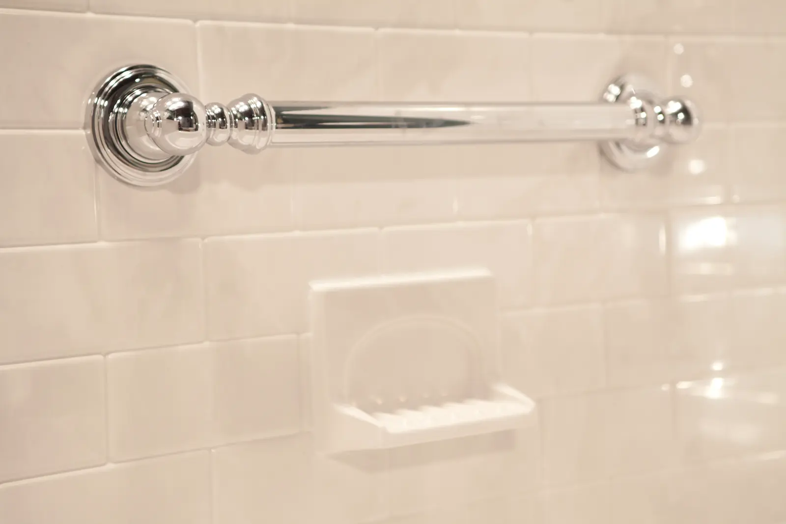 Chrome Chateau grab bar with soap dish on silver white subway walls