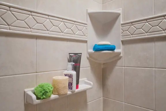 Corner shelf with listello trim and tile walls