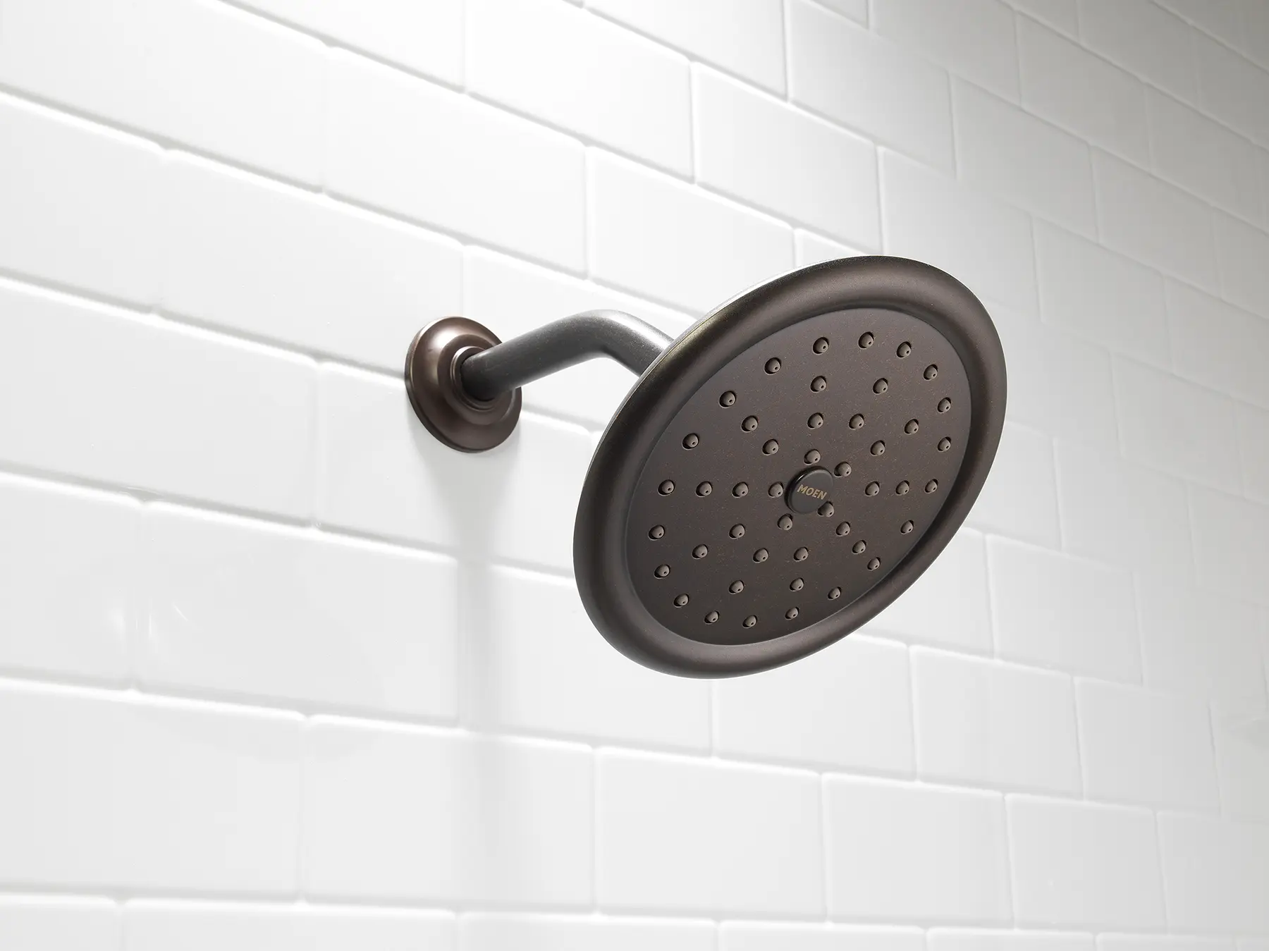 Oil-rubbed bronze rain shower head on white subway tile