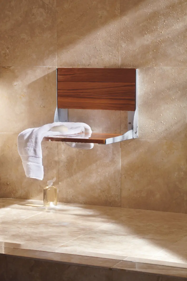 Fold-down teak shower seat on travertine wall surround