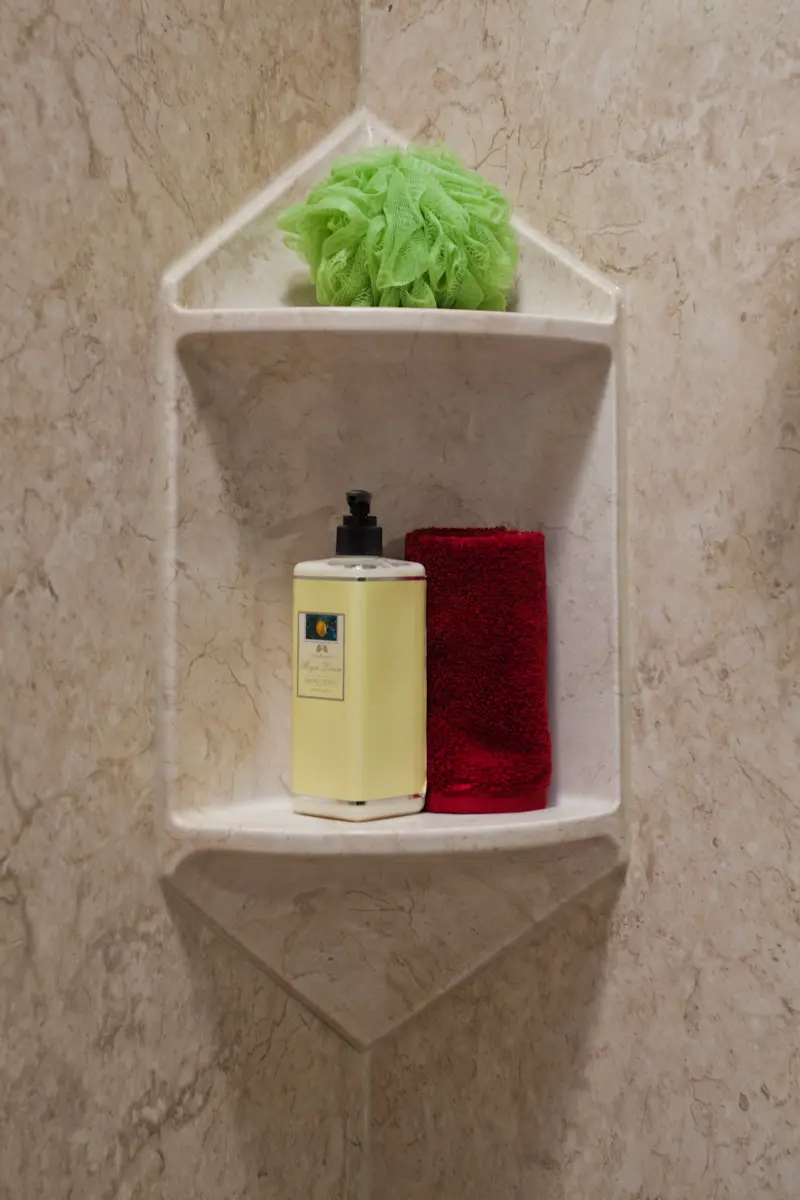 Two-shelf corner caddy in travertine smooth wall