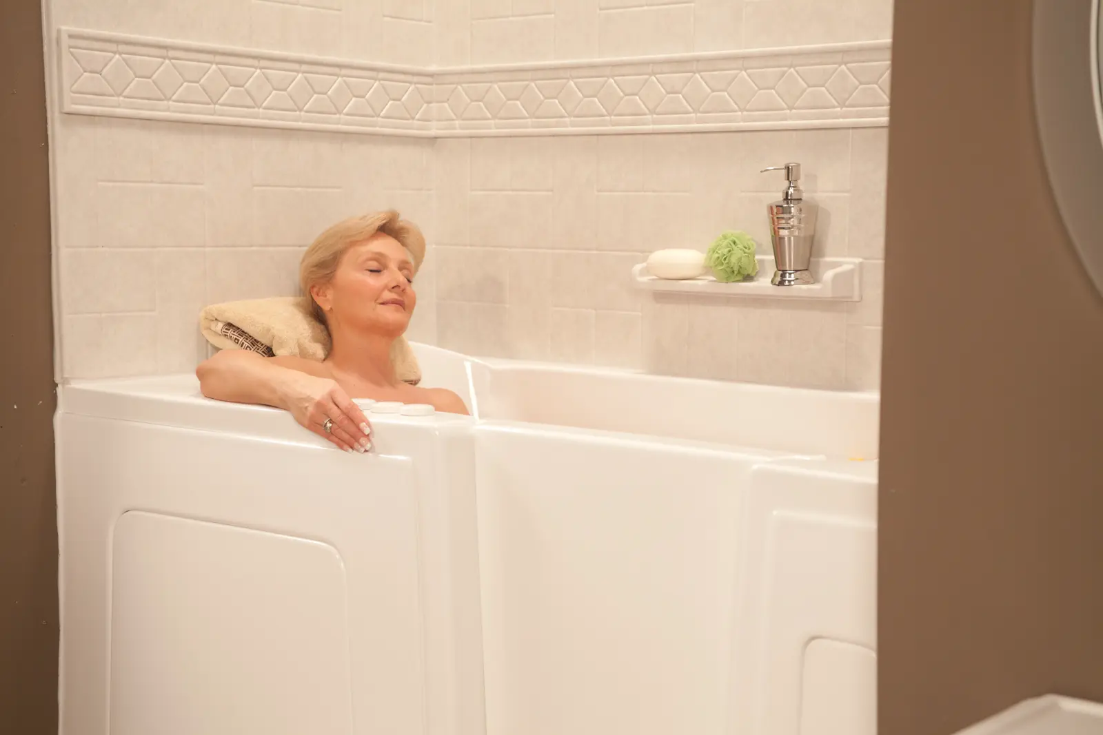 Woman relaxing in a walk-in tub with Roman stone surround