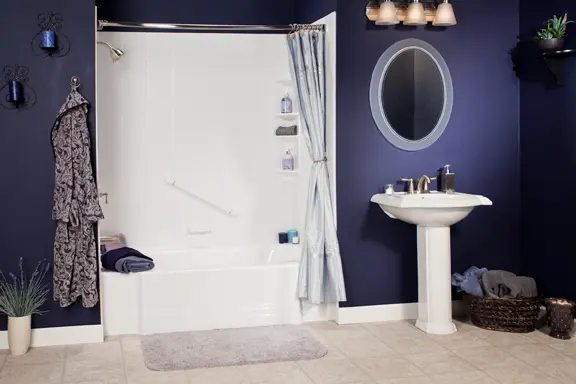 White tub and shower combo with navy blue walls